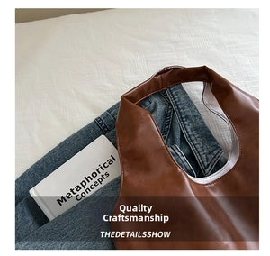 Overhead view of a brown oil wax leather tote bag with white lining and top handles