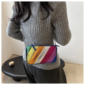 Detailed view of rainbow metallic crossbody bag with silver studs and chain strap