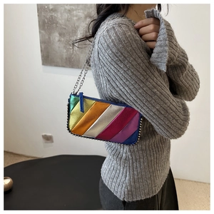 Detail of colorful metallic patchwork bag with silver rivets and sleek chain strap