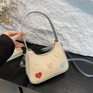 Chic beige crescent underarm bag with colorful heart patches and silver trim finish