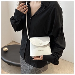 Close-up of minimalist white PU leather crossbody bag with FASHION & BAGS lettering