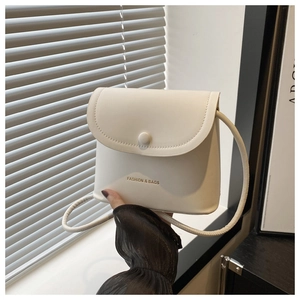 Detail of white PU leather bucket bag with magnetic clasp and printed fashion logo