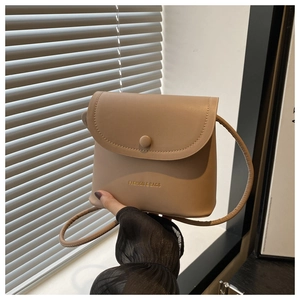 Close-up of beige leather mini bucket bag featuring a gold Fashion & Bags logo print
