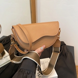 Vintage tan leather saddle bag with wide shoulder strap and polished gold hardware