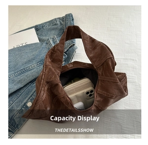 Spacious interior of brown pleated tote bag holding phone, wallet, and headphones