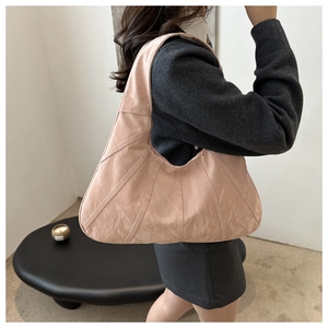 Macro detail of a light pink pleated hobo bag with unique vertical stitching texture