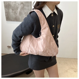 Detail showing the pleated texture and soft pink synthetic leather of the tote bag