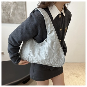 Detail of silver metallic pleated hobo bag showing the unique texture and shoulder fit