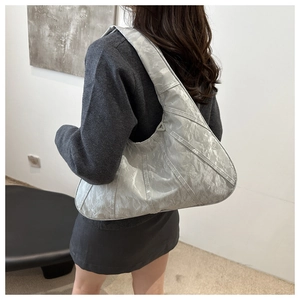 Detail view of silver pleated crescent shoulder bag with radial quilted stitching texture