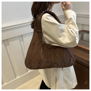 Side view of brown pleated texture tote bag worn by model for casual daily styling