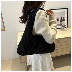 Close-up of black shoulder bag with pleated texture and semi-circle structure