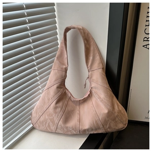 Detail of pink marble textured shoulder bag with pleated fan design on window sill