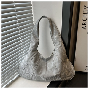 Detail of silver-grey hobo bag featuring crinkled texture and sleek hobo half-moon design