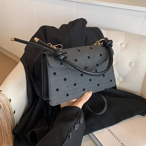 Polka dot herringbone handbag with black leather straps and gold hardware details