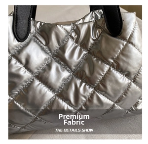 Detail shot of silver quilted puffer bag fabric with metallic finish and diamond stitching