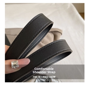 Detail of coffee brown leather shoulder strap with fine stitching and litchi texture