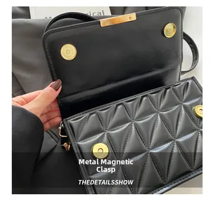 Detail of black quilted leather bag featuring dual magnetic snap closures and fine stitching