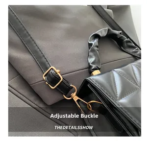 Detail of adjustable golden metal buckle on black quilted leather crossbody bag strap