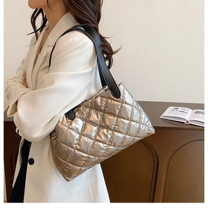 Close-up of metallic silver quilted puffer bag with sleek black leather shoulder strap
