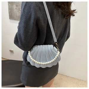 Detail of shell-shaped crossbody bag with pearl decoration and pleated texture