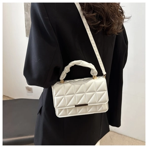 Detailed view of white quilted square handbag with ruched handle and gold metal hardware
