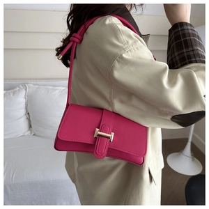 Fashionable rose pink underarm bag with gold metal buckle shown on a model