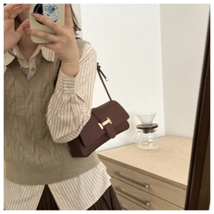 Chic burgundy leather flap bag with gold H-shaped buckle shown in a mirror selfie