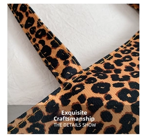 Close-up of leopard print tote bag handle with reinforced yellow stitching details
