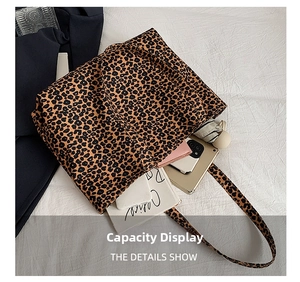 Spacious interior of leopard print tote bag holding umbrella, phone, and magazines