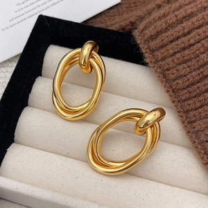 Modern double oval gold earrings with polished finish displayed in a jewelry box