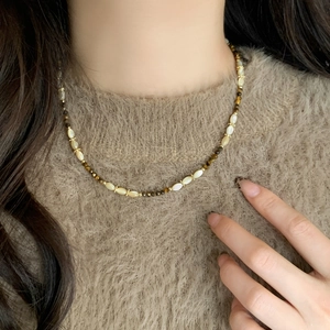 Natural stone and shell beaded necklace on camel sweater for autumn winter style