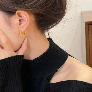 Minimalist gold-plated twisted geometric hoop earrings shown on a model for daily style