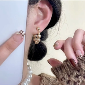 Eleganti orecchini a goccia in oro champagne indossati da una modella per un look di classe