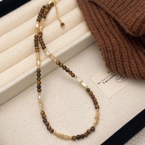 Handmade tiger eye and shell beaded necklace in brown tones displayed in jewelry box