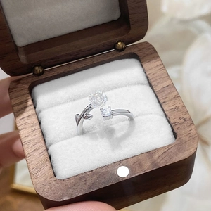 Detail of adjustable camellia ring with white flower and zircon in a luxury wood box