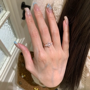 Detailed view of rose gold flower ring with pink shell inlay and sparkling white diamonds
