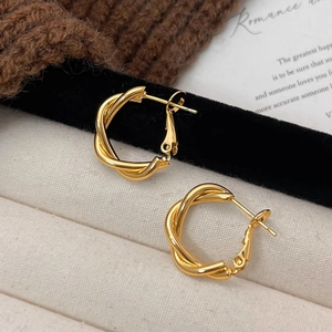 Minimalist geometric twisted gold hoop earrings with irregular double line cross design
