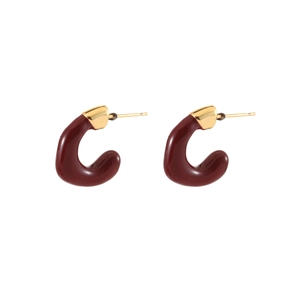 Macro detail of red enamel C-shaped hoop earrings with gold plated metallic finish