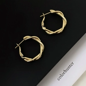 Macro detail of 18K gold plated twisted hoop earrings with a secure clasp design