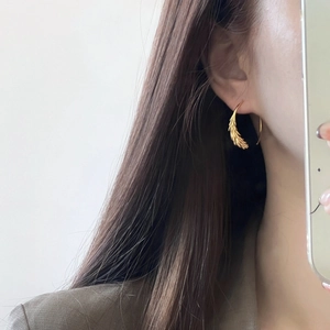 Détails rapprochés des boucles d'oreilles épi de blé plaqué or aux textures fines