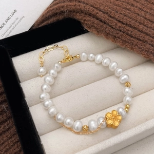 Natural freshwater pearl bracelet with a golden flower charm and heart extender chain