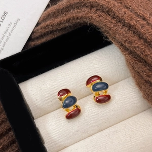Vintage gold stud earrings with red and blue stones in a velvet jewelry box