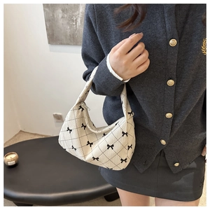 Detail of corduroy hobo bag with bow print and diamond quilted texture for women