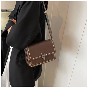 Brown crossbody bag featuring gold studs and ethnic style embroidered wide strap