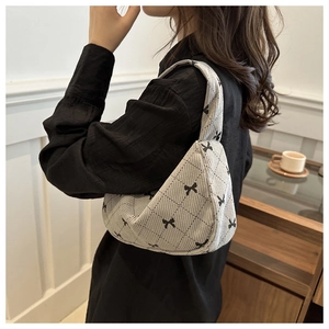 Detail of grey corduroy pillow bag with bow print and quilted pattern on shoulder