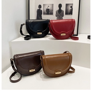 Borse a sella in pelle in quattro colori esposte su supporti geometrici minimalisti