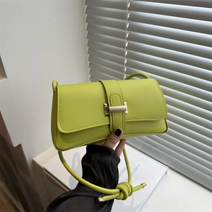 Lime green leather baguette bag with gold magnetic buckle and decorative knotted strap