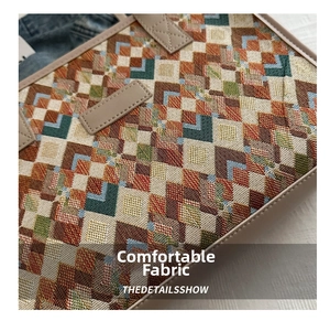 Macro detail of geometric woven canvas texture and cream leather trim on tote bag