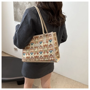 Dettaglio del motivo jacquard geometrico vintage e manici in pelle della borsa
