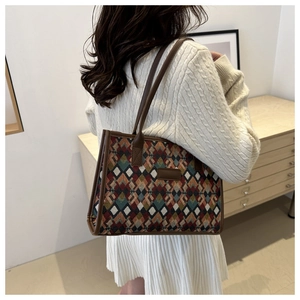 Detailed shot of ethnic pattern tote bag with leather straps on model in cozy setting